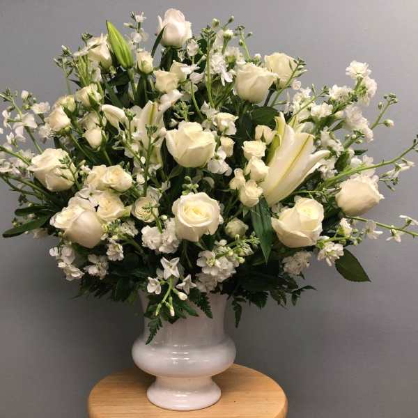 White roses and lilies arranged in a white vase