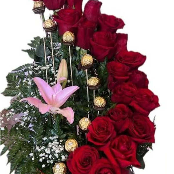 Red roses with pink lilies and chocolate truffles in a floral arrangement