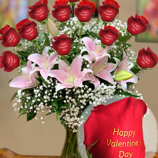 Bouquet of red roses and pink lilies in a glass vase
