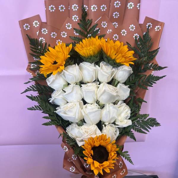 Bouquet of white roses and yellow sunflowers wrapped in brown paper