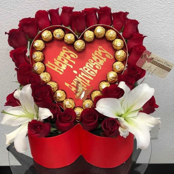 Heart-shaped rose arrangement with chocolates and white lilies