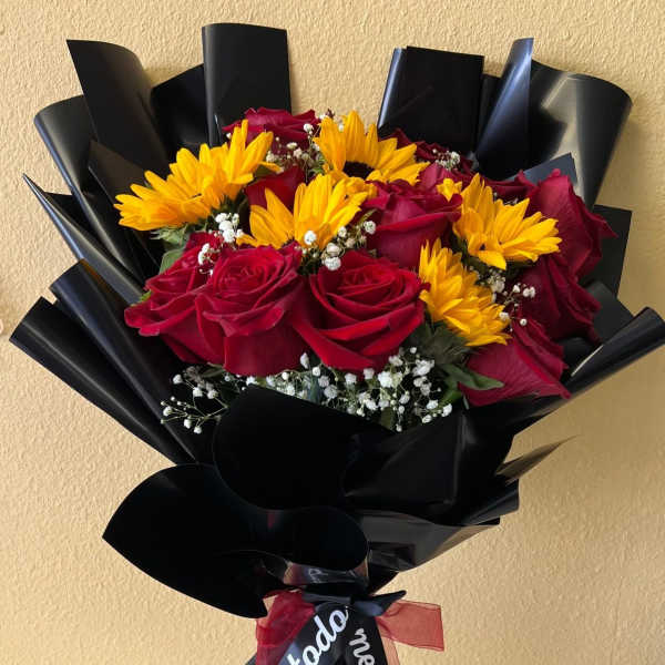 Bouquet of red roses and yellow daisies wrapped in black paper