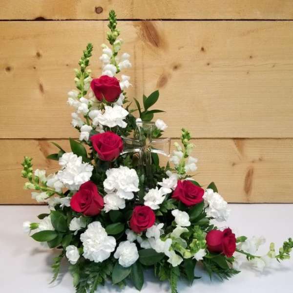 Red roses and white carnations arranged in a clear glass vase