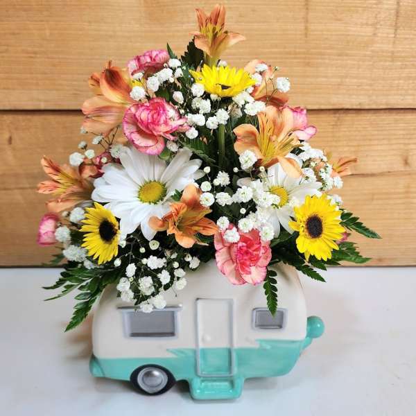 Mixed flower arrangement in a camper-shaped ceramic container
