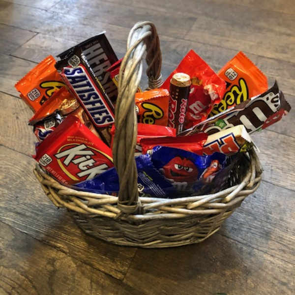 Wicker basket filled with assorted candy bars and chocolates