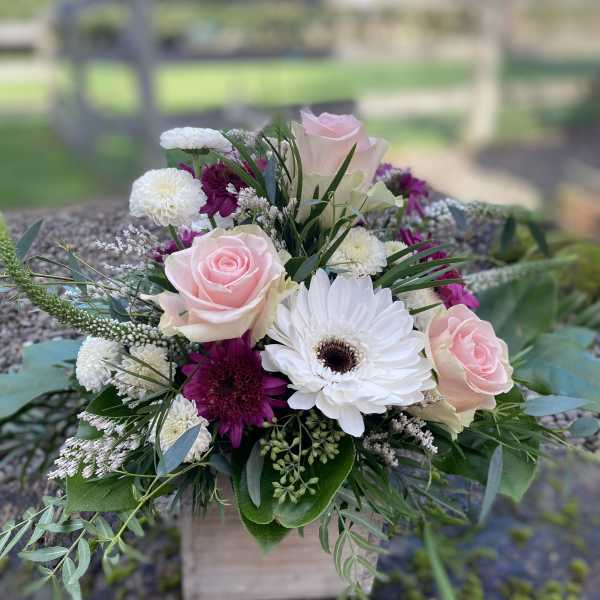 Pink roses and white daisies in a low bouquet