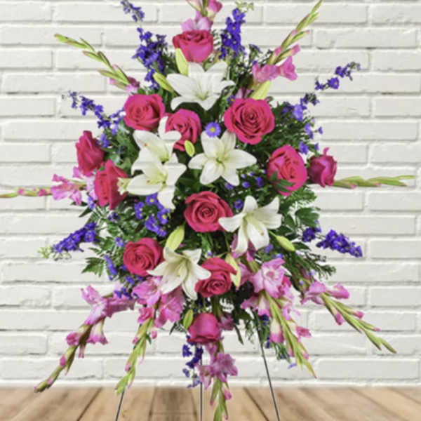 Standing floral spray with pink roses, white lilies, and purple accents