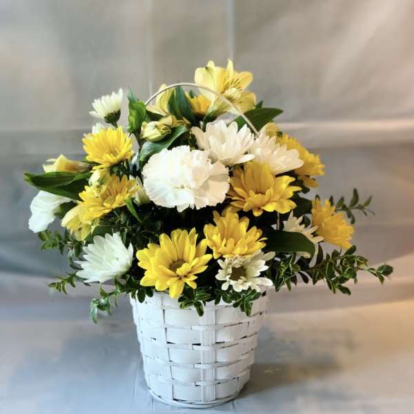 Yellow and white daisy bouquet in a white basket