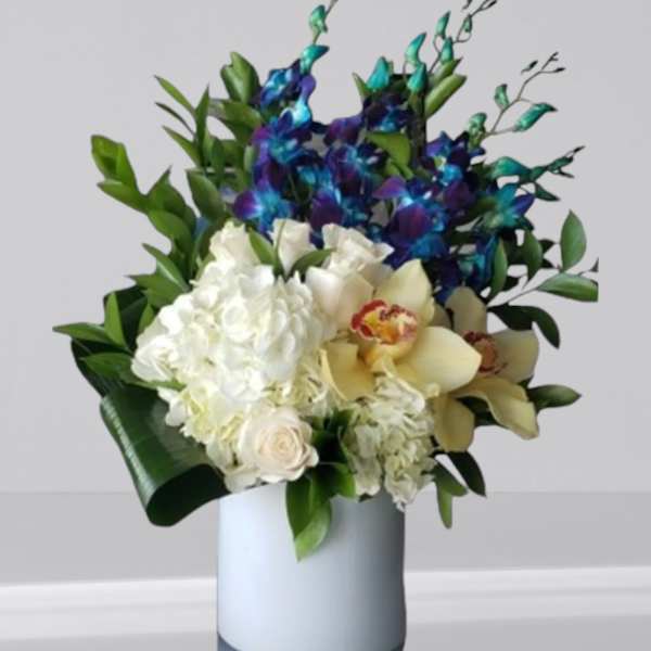 White and blue floral arrangement in a light vase