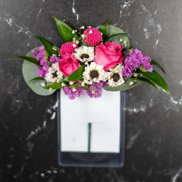 Pink roses and white daisies arranged in a rectangular vase