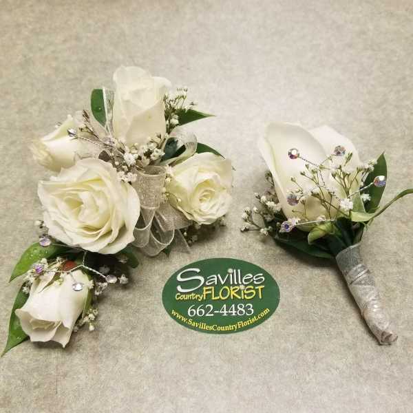 White rose boutonnieres with silver ribbon and rhinestone accents