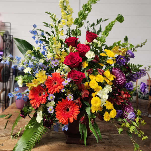 Large mixed flower arrangement with roses, gerberas, and snapdragons in a vase