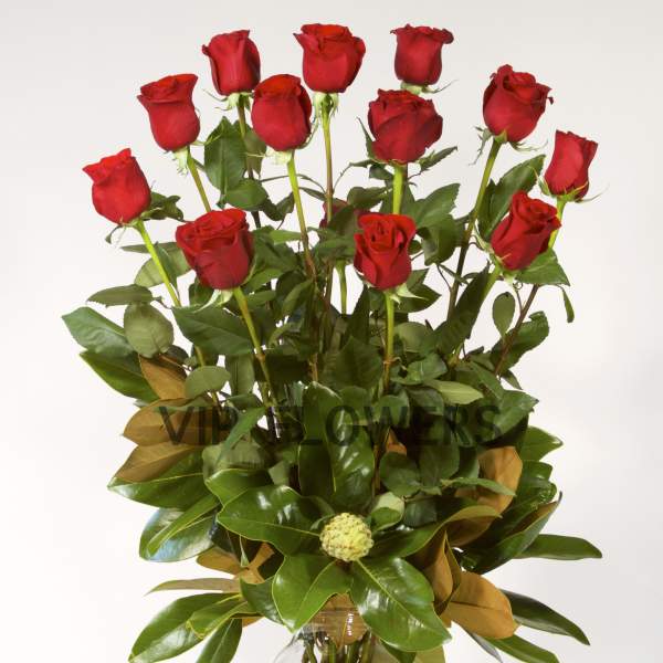 Tall bouquet of red roses in a clear glass vase