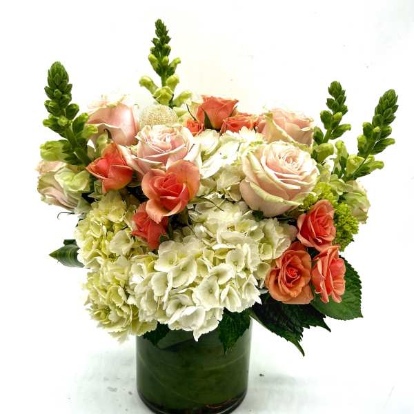 Pink roses and white hydrangeas in a green glass vase