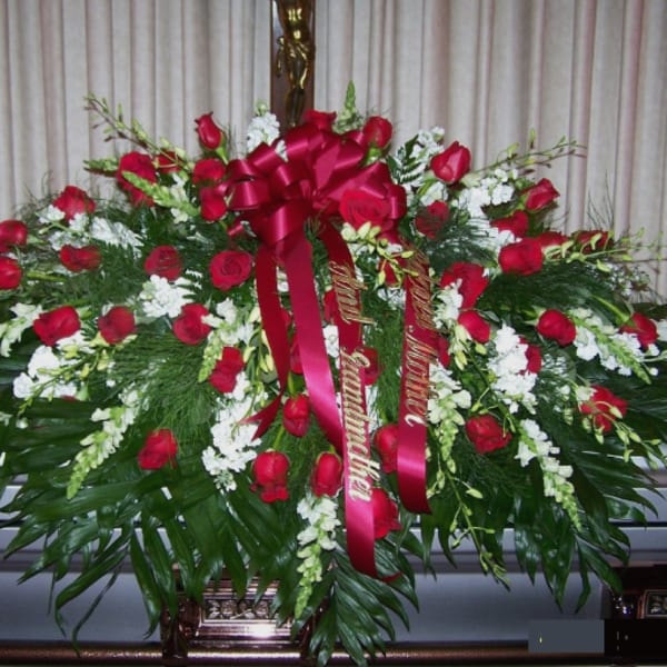Large red rose casket spray with white flowers and ribbon