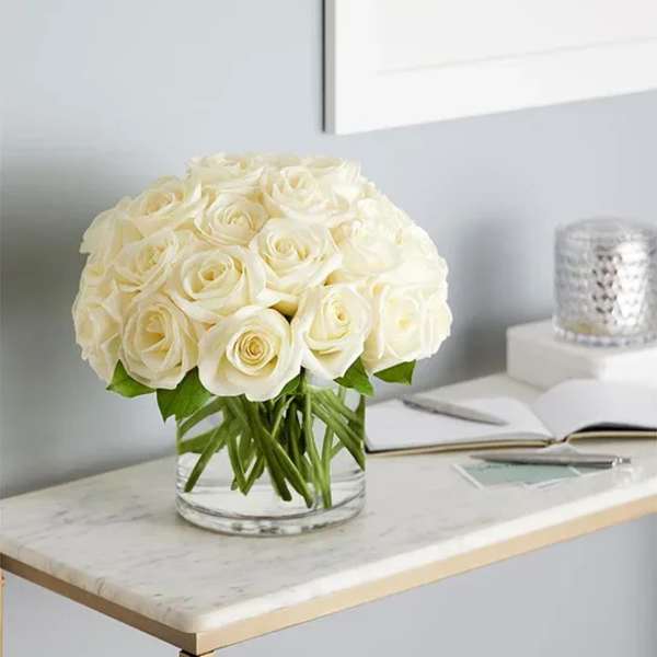 White rose bouquet in a clear glass vase on a table