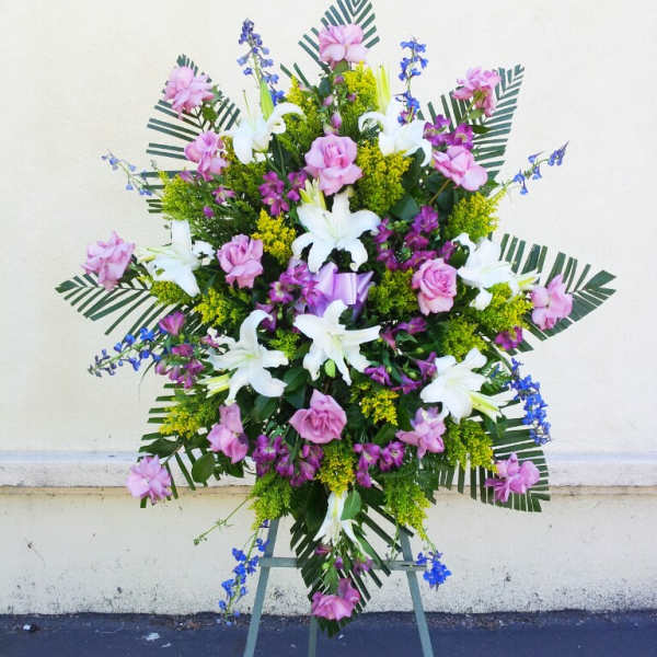Standing floral spray with pink and white lilies on an easel