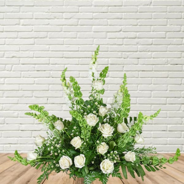 White rose arrangement with tall green spikes in a low design