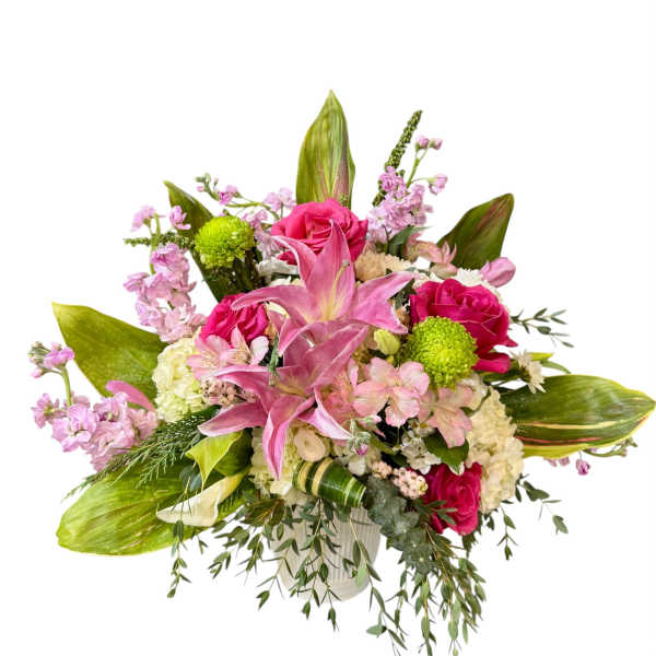 Pink lilies and roses in a white vase with mixed blooms