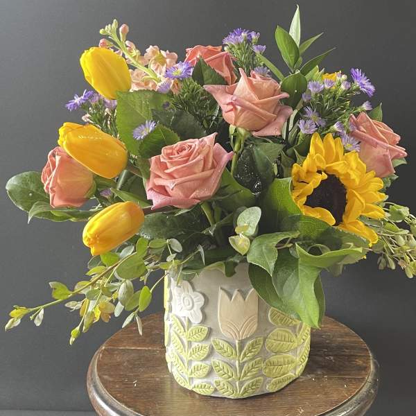 Bouquet of pink roses and yellow tulips in a decorative ceramic vase