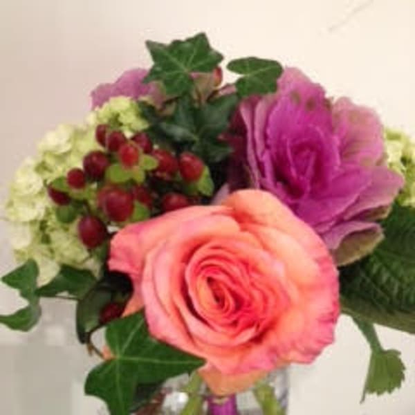 Small arrangement with a peach rose, green hydrangea, and purple ornamental cabbage in a glass vase