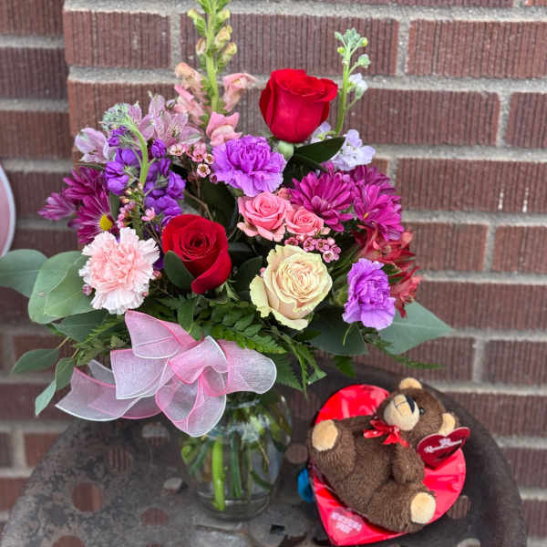 Mixed bouquet in a glass vase with a teddy bear gift