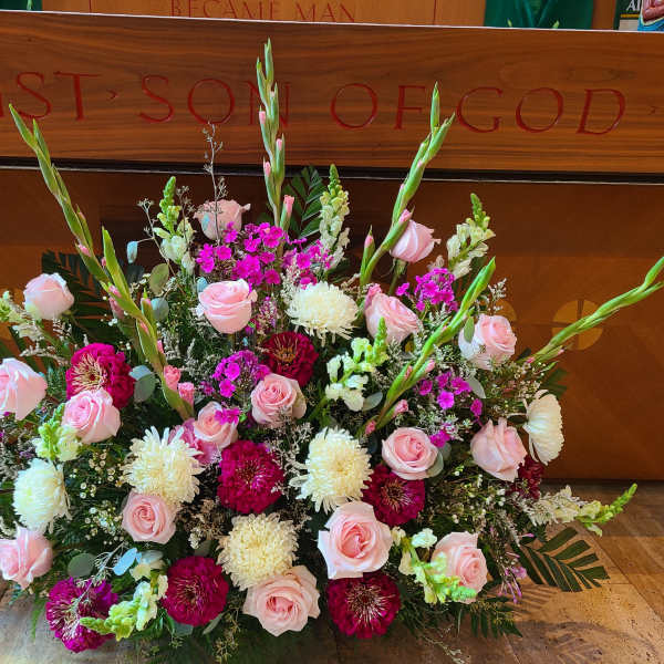 Large floral arrangement with pink roses, white mums, and magenta blooms