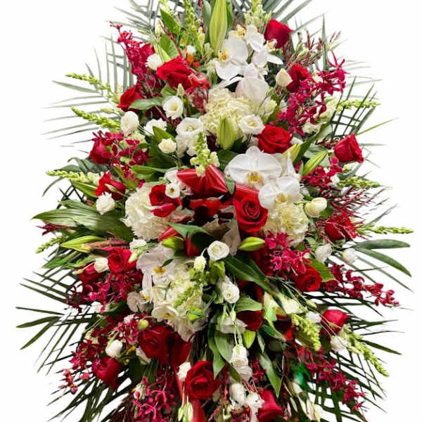 Large standing spray of red and white flowers with palm fronds