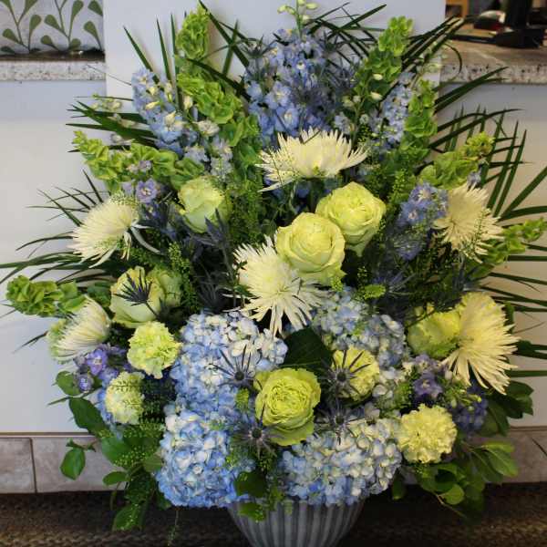 Blue and yellow floral arrangement in a vase