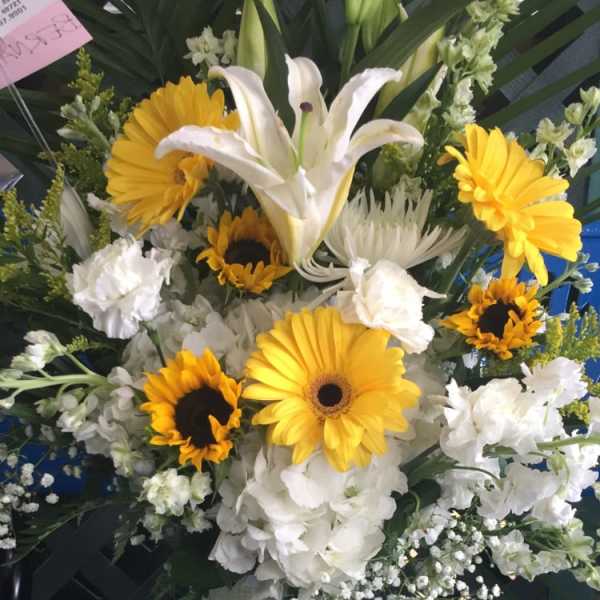White lilies and yellow gerbera daisies in a vase