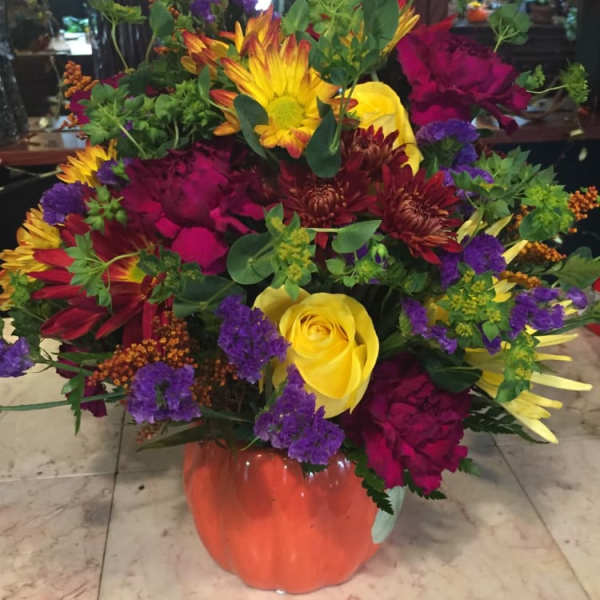 Colorful mixed flower arrangement in an orange vase
