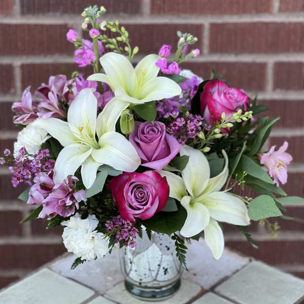 Bouquet of white lilies and pink roses in a glass vase
