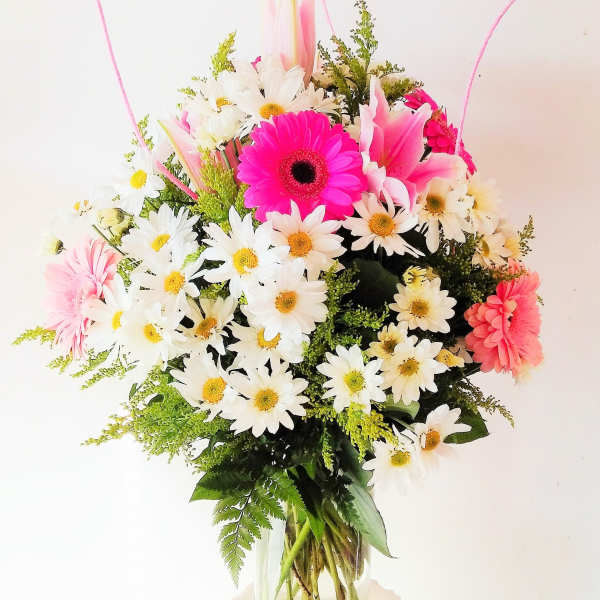 Pink and white daisy bouquet in a clear glass vase