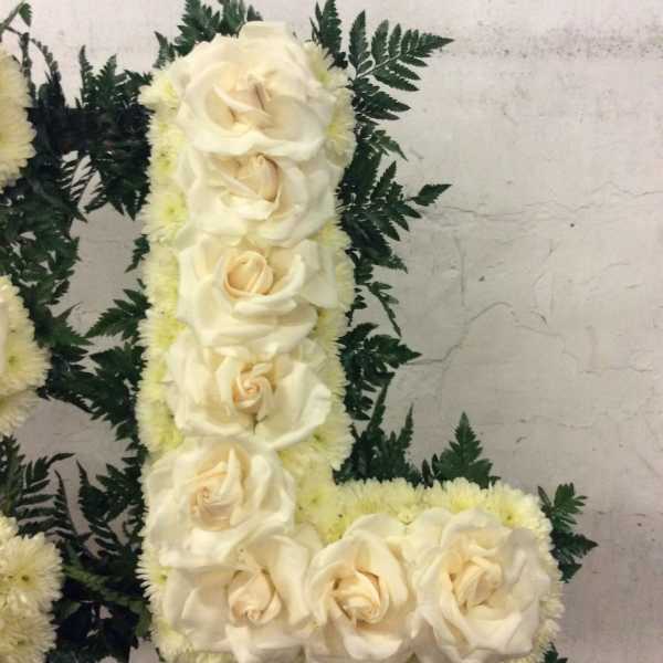 White rose floral arrangement with dark fern foliage