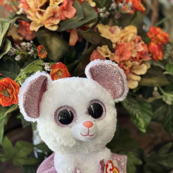 White plush mouse in a pink tutu in front of orange flowers