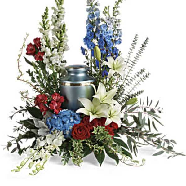 Sympathy arrangement with red, white, and blue flowers around a silver urn