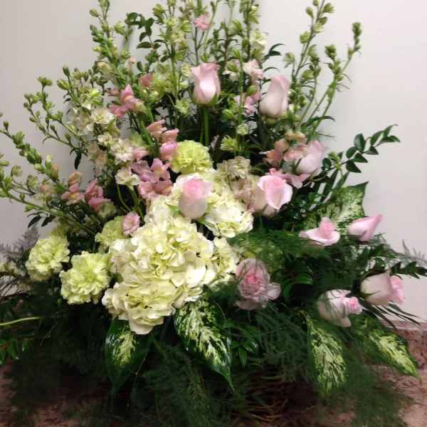 Tall floral arrangement with pink roses and pale hydrangeas