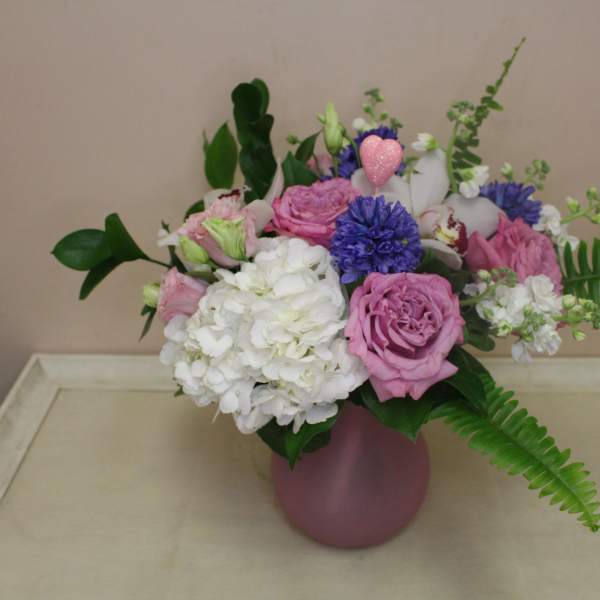 Pink and white flower arrangement in a pink vase