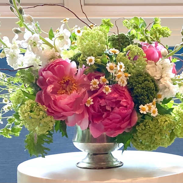 Pink and white floral arrangement in a silver vase