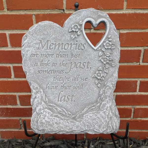 Heart-shaped memorial stone with floral decoration and engraved text