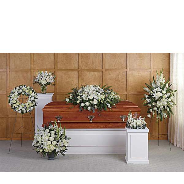 White funeral flowers arranged around a casket