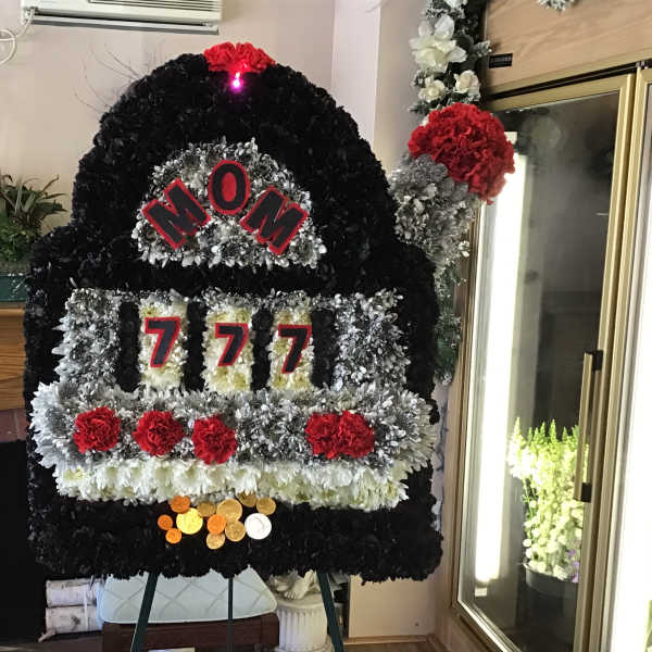 Large floral tribute shaped like a slot machine with red and black flowers