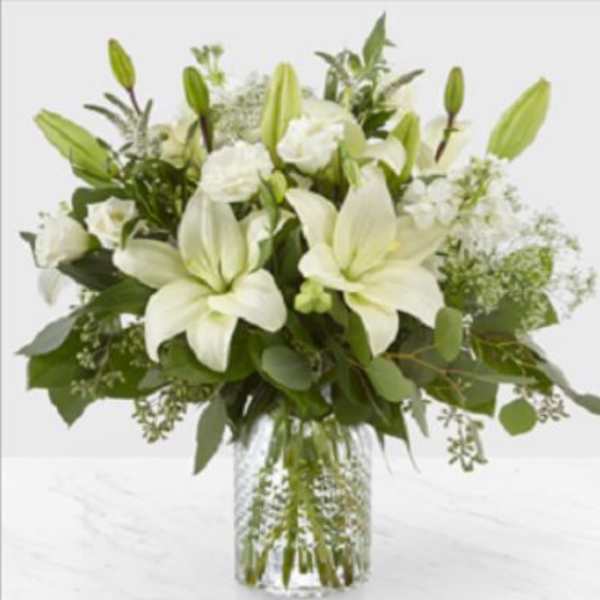 White lilies and roses in a clear glass vase