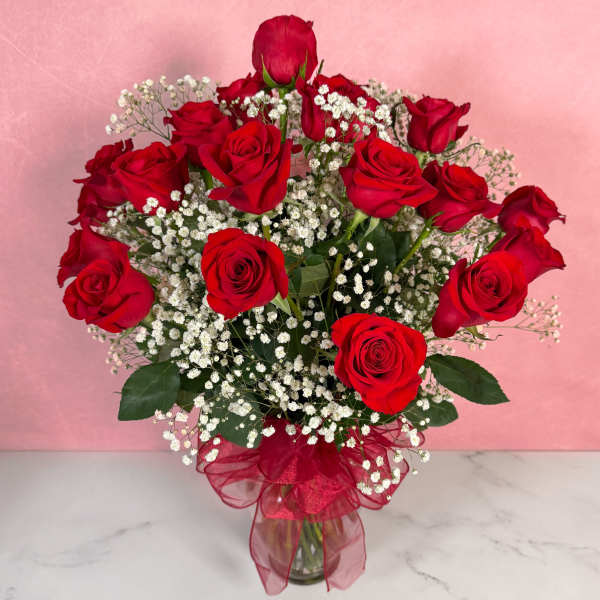 Bouquet of red roses with white baby's breath in a glass vase