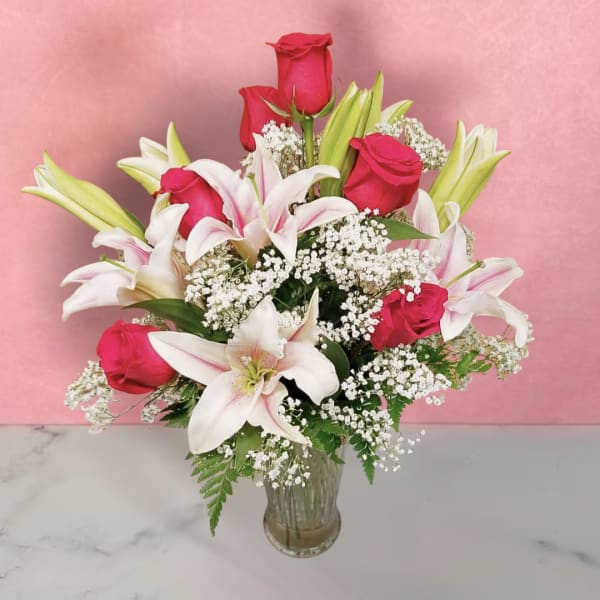 Bouquet of pink roses and white lilies in a clear glass vase
