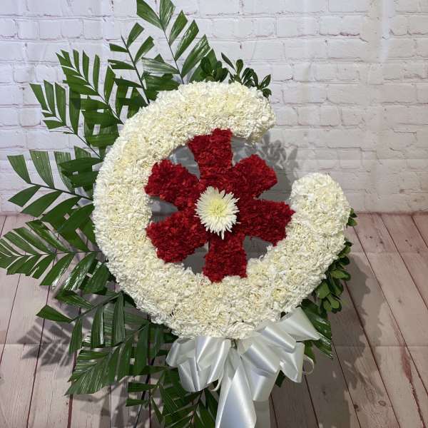 Large floral wreath with red and white flowers and a white ribbon bow