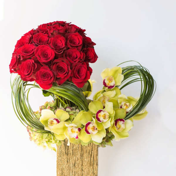 Red roses and yellow orchids in a gold vase