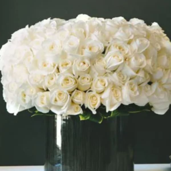 White rose arrangement in a black vase