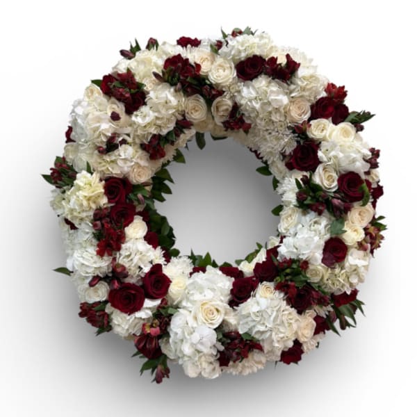 Circular floral wreath of white and deep red flowers