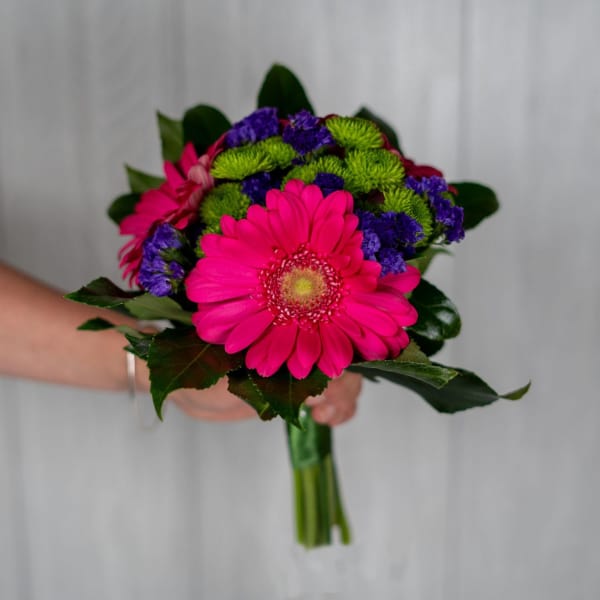 Handheld bouquet with hot pink gerbera daisies and purple-green mums